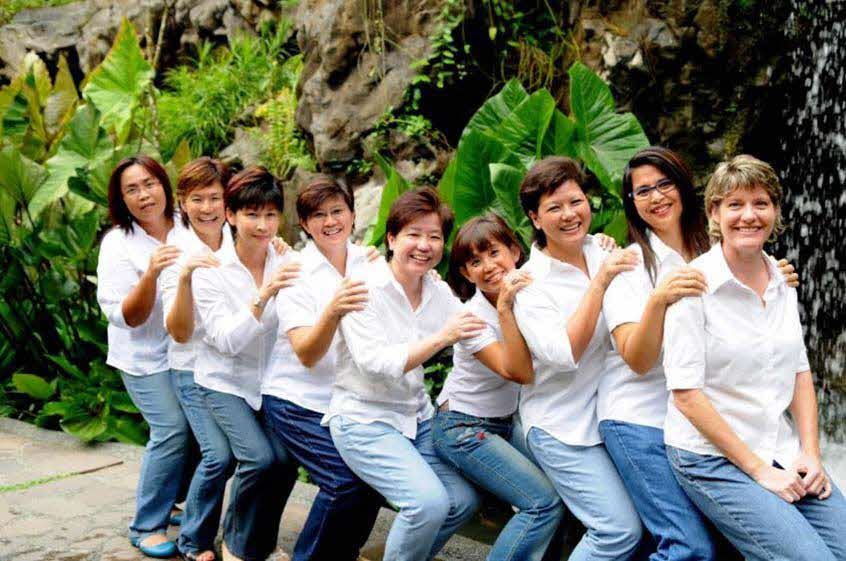 A group of woman smiling and posed in a line